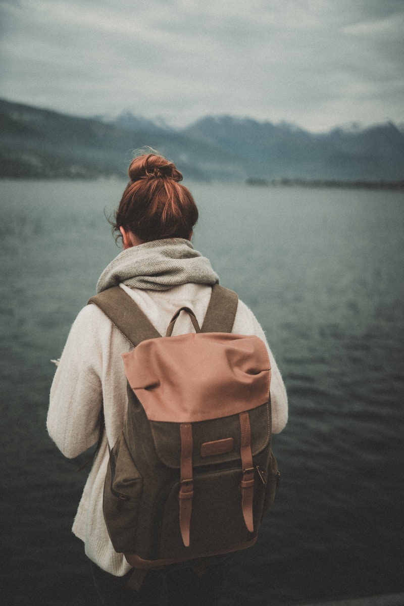 woman standing nearby calm body of water ]